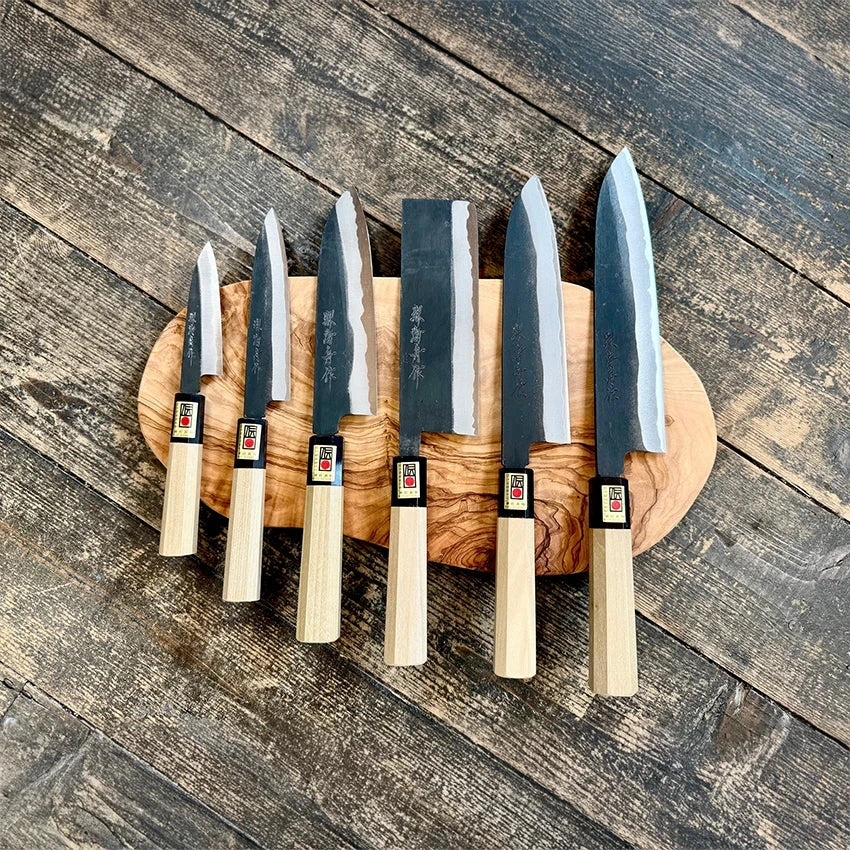 A Japanese kitchen knife with a light wooden handle and a steel blade featuring engraved Japanese characters.