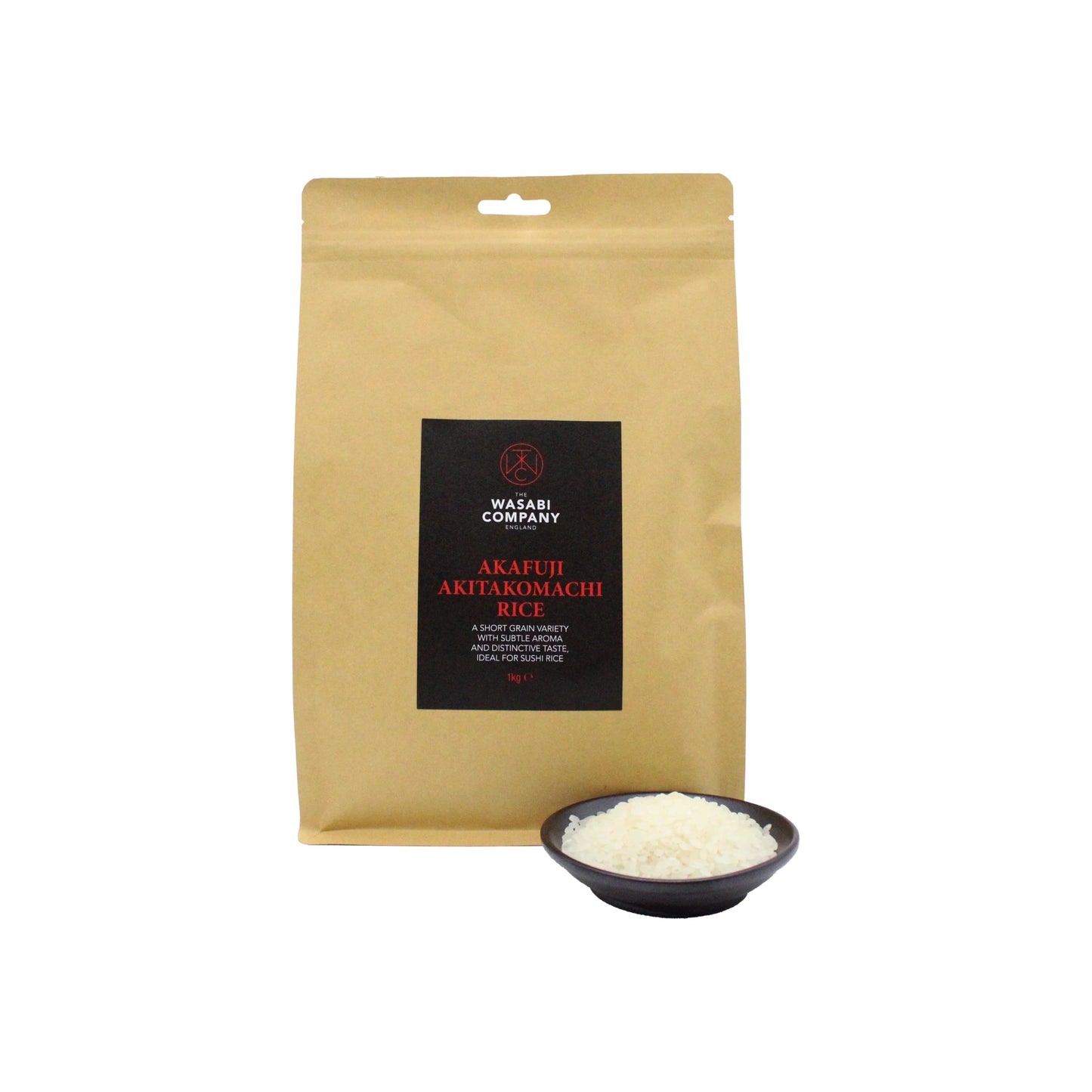 A brown bag labeled Wasabi Label Akafuji Akitakomachi Rice stands behind a small black bowl filled with fluffy Japanese short-grain rice.