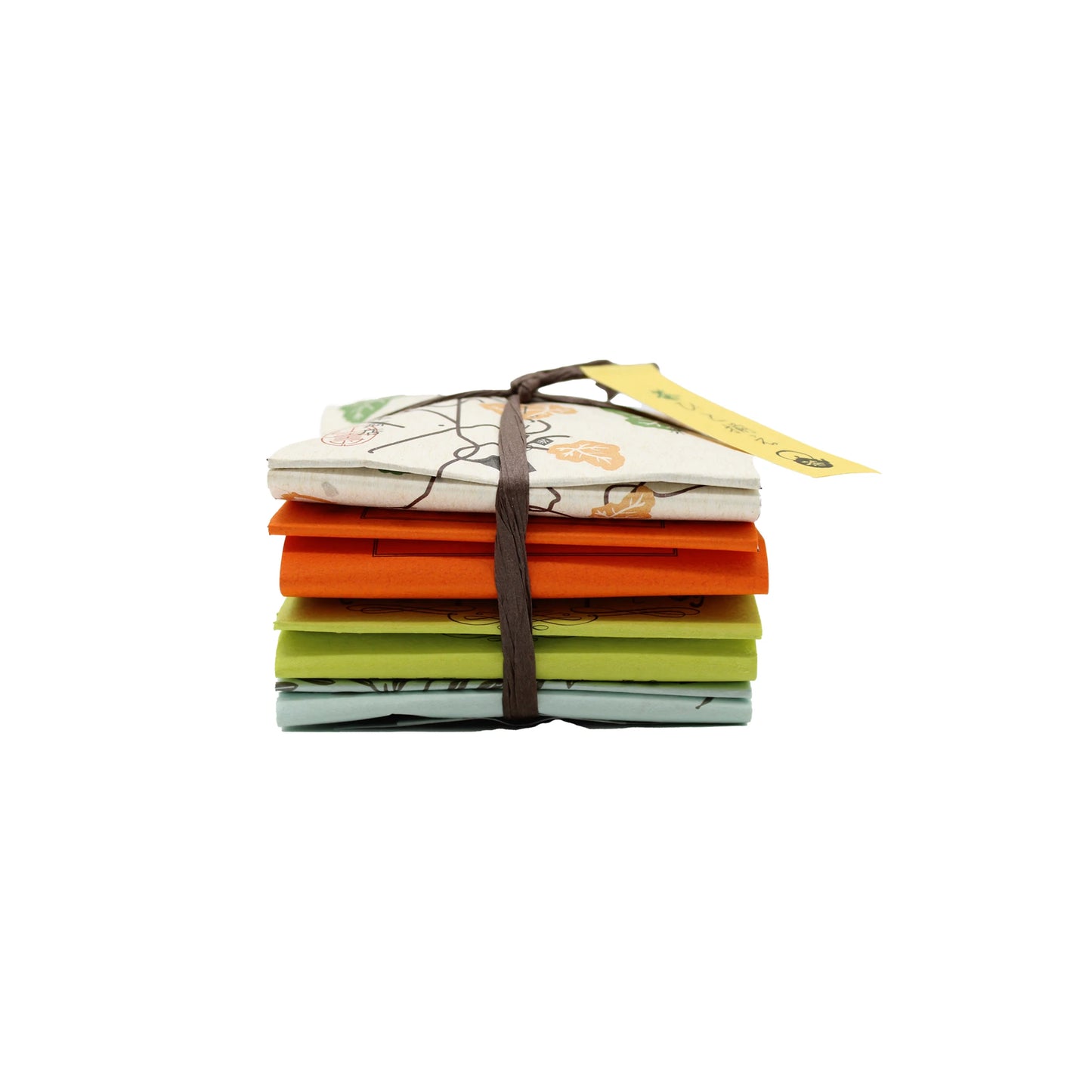 A stack of four pastel cloths tied with string and a yellow tag, evoking the refined look of premium sencha, showcases the Japanese Tea Assortment (8 bags, 4 different teas).
