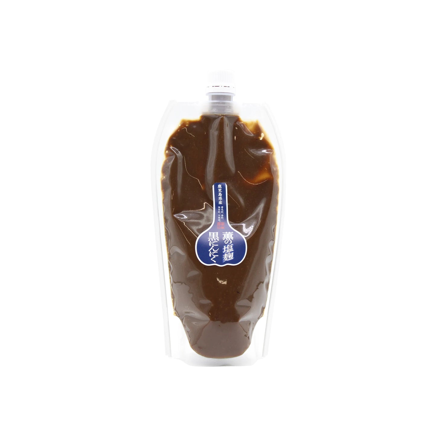 A clear plastic pouch labeled Black Garlic Shio Koji with Japanese text on a blue sticker, filled with dark brown umami sauce and sealed with a white cap.