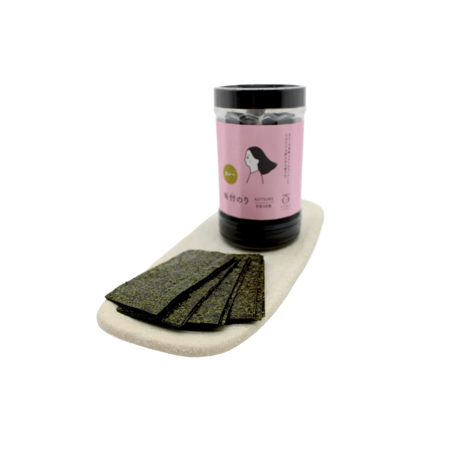 A container of Curry Flavoured Nori Snacks with a pink label stands on a tray beside several rectangular sheets of roasted seaweed.