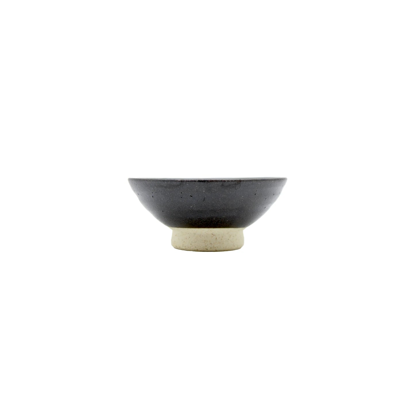 The Sake Cup - Flat Sakazuki in Black Iga Vortex is a small ceramic bowl with a dark gray top and light beige base, inspired by traditional sakazuki cups, shown on a plain white background.
