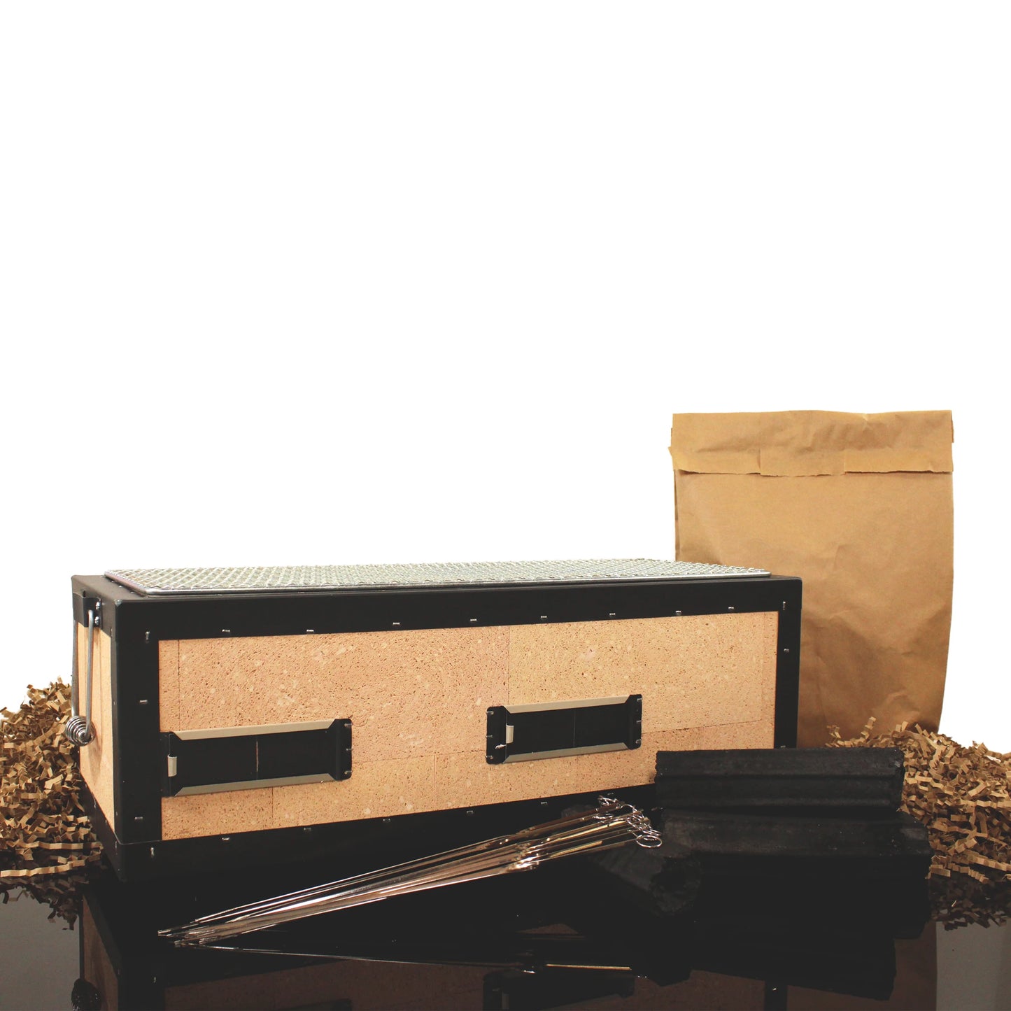 The Konro Grill 54cm Barbecue Set, including a rectangular wooden box with metal accents, a brown paper bag, packing material, and long metal skewers, is displayed on a black surface—ideal for Japanese BBQ.