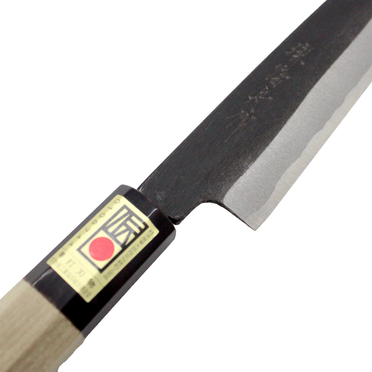 Close-up of the Petty Paring Knife Double Bevel Black Forged - 150mm, showing its wooden handle, partially black blade, double-bevel edge, and a label with Japanese text and a red circle.