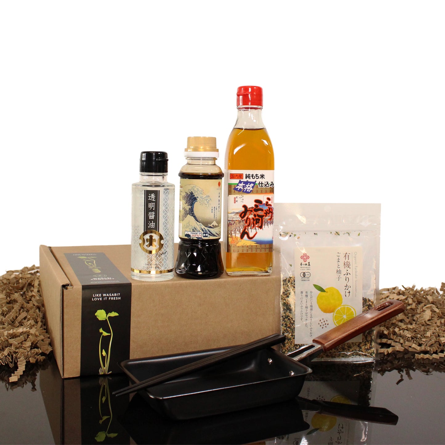 The Tamagoyaki Breakfast Kit features a box, soy sauce, vinegar, sauce packet, ceramic dish, and wooden-handled grater—ideal for rolled omelette fans and Japanese cuisine lovers. Elegantly displayed on a white background.