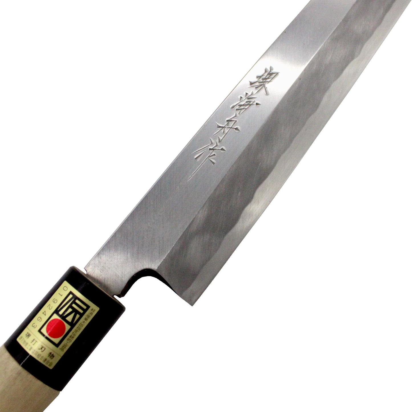 A close-up of the Yanagiba Sashimi Knife Migaki Polished - 300mm shows kanji engraved on its blade and a wooden handle with a small label, making it ideal for precise sushi preparation.