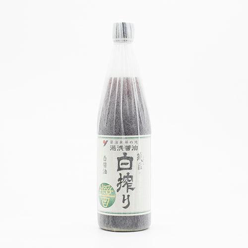 A clear bottle of Kurano Shiroshibori White Soy Sauce with a white, Japanese-labeled design and green accents stands against a plain white background—an elegant staple in Japanese cuisine.