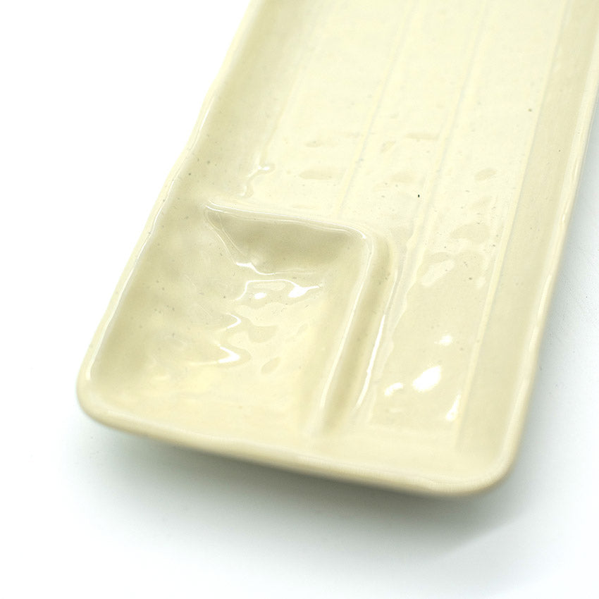 The Gyoza Plate in Ivory features a minimalist rectangular design with an integrated sauce dish in one corner, crafted from Japanese porcelain and set against a white background.