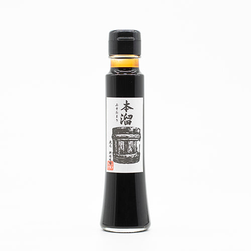 A glass bottle of Hon Tamari Soy Sauce is gluten free, has a black cap, and a white label with Japanese text and a barrel illustration.