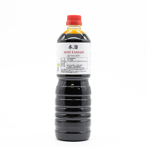 A plastic bottle of Hon Tamari Soy Sauce with a red cap and white label stands upright on a plain white background. This gluten-free soy sauce is ideal for anyone seeking authentic Japanese flavor.