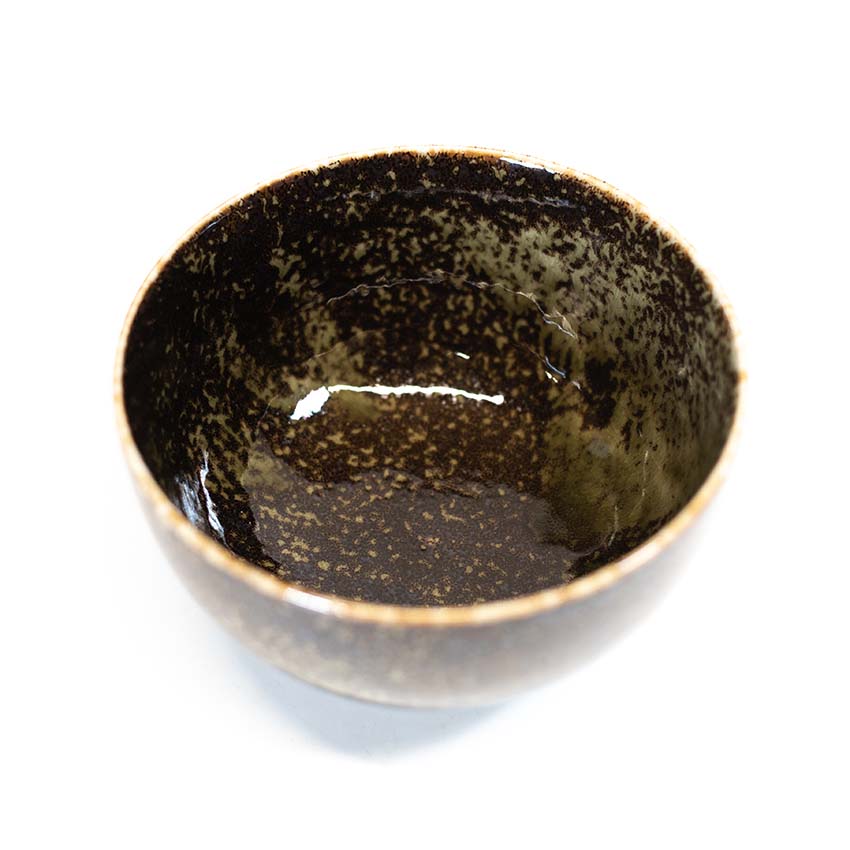 The Miso Bowl - Black & Sage is a handmade ceramic bowl with a dark, speckled glaze, perfect for serving miso soup. Shown from an overhead angle on a white background.