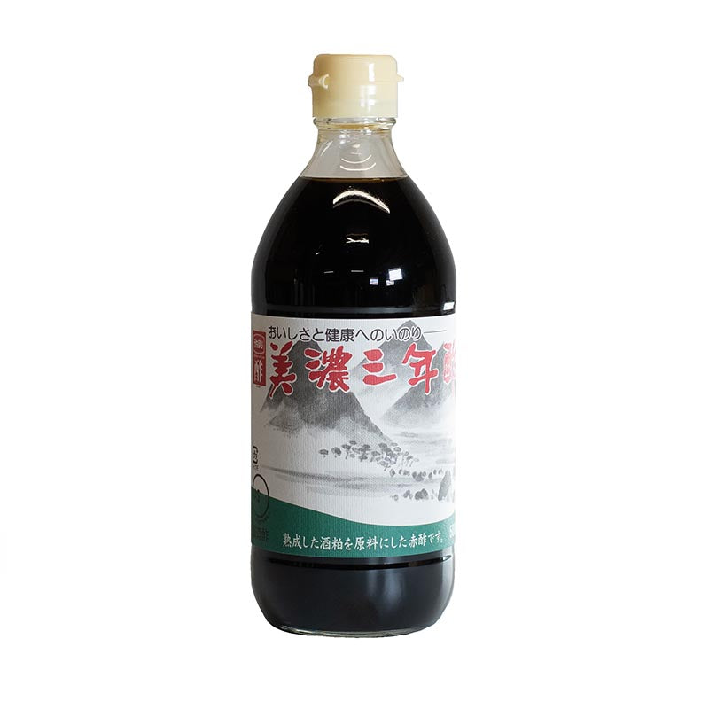 A 500ml bottle of Red Sake Kasu Vinegar, aged 3 years, with a light cap and a Japanese label featuring mountains and water; crafted to be gluten free for those with dietary preferences.