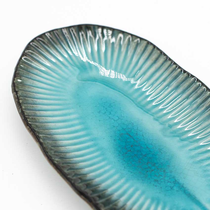 A close-up of the Sashimi Platter - Oval in Sky Blue 21cm, showcasing its textured rim and glossy blue-turquoise gradient glaze.