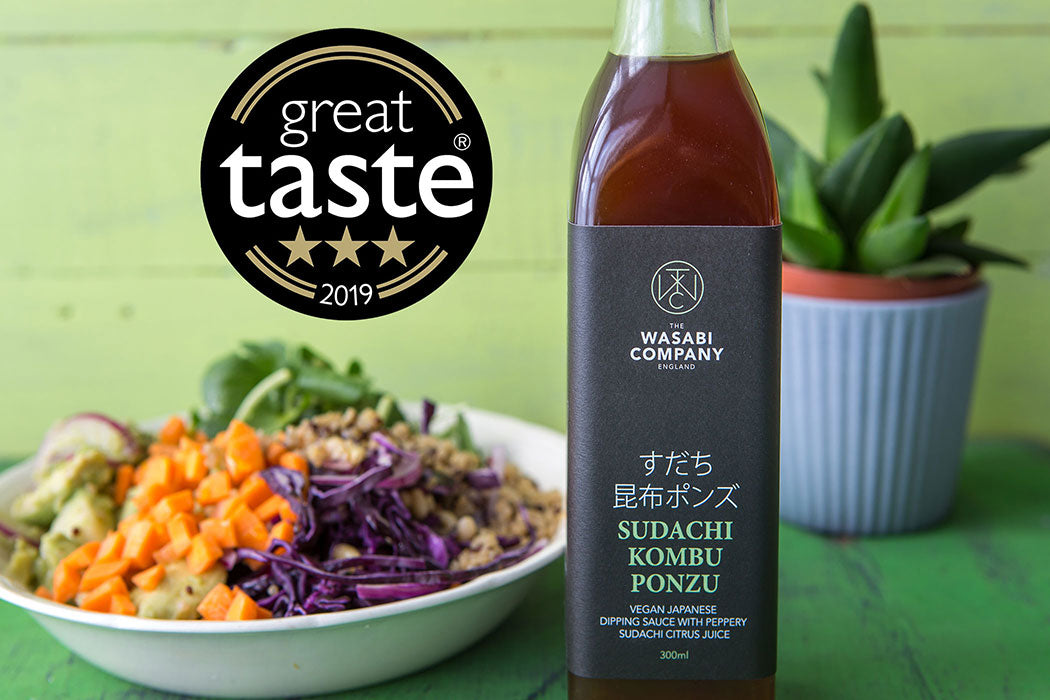 A 300ml bottle of Sudachi Kombu Ponzu is placed beside a salad bowl, with a Great Taste 2019 award badge visible in the background.