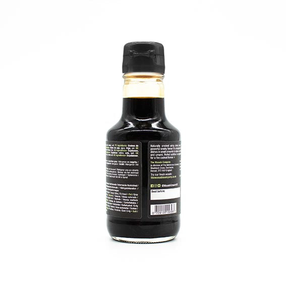 A 150ml bottle of Smoked Soy Sauce with a black cap, viewed from the back, displays product details and a barcode on its label. Enhance your favorite dishes with its unique smoky flavor. Vegan friendly.