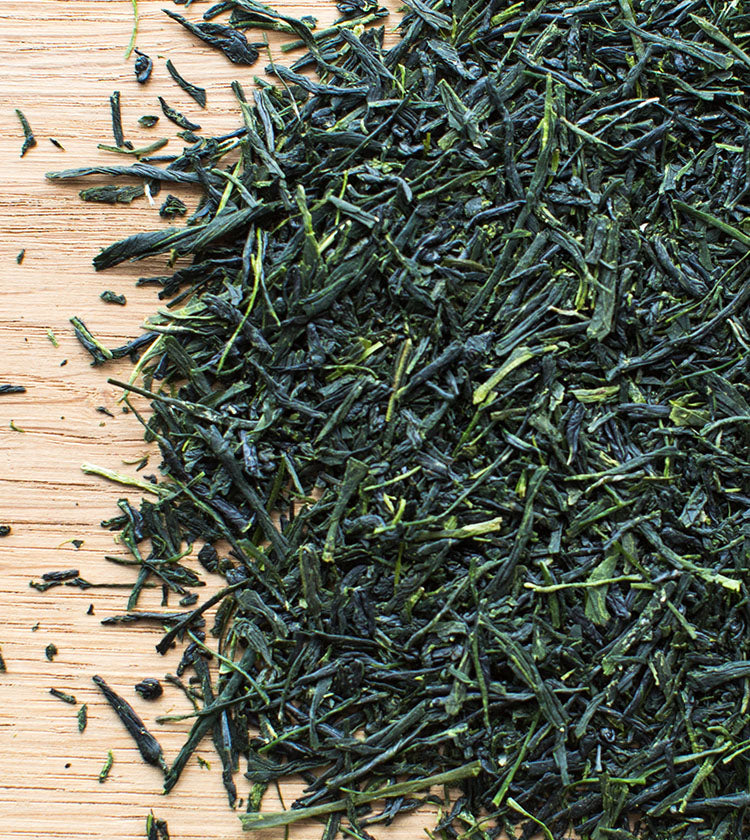 Sencha Superior Tea - 50g loose leaves are spread on a wooden surface, perfect for brewing a mellow-flavored green tea.