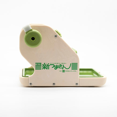 The Vegetable & Fruit Cutter, a beige and green kitchen tool with Japanese text on the side, is designed for making sushi rolls and versatile slicing. It is displayed against a plain white background.