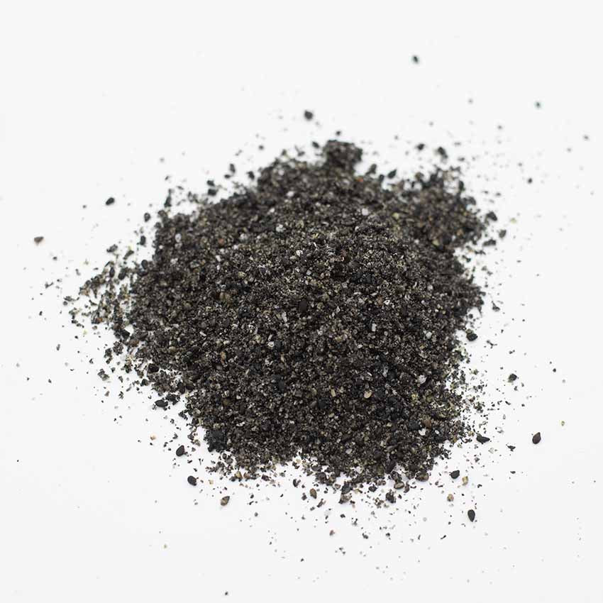 A small pile of Wadaman Gomashio - 50g, known for its flavour-boosting coarse black sesame seeds, rests on a plain white background.