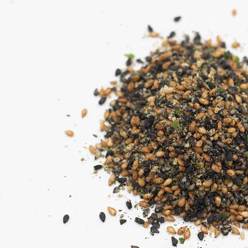 Wadaman Furikake Sesame & Sansho Pepper 30g, a blend of toasted sesame seeds, sansho pepper, seaweed flakes, and spices, is scattered on a white surface.