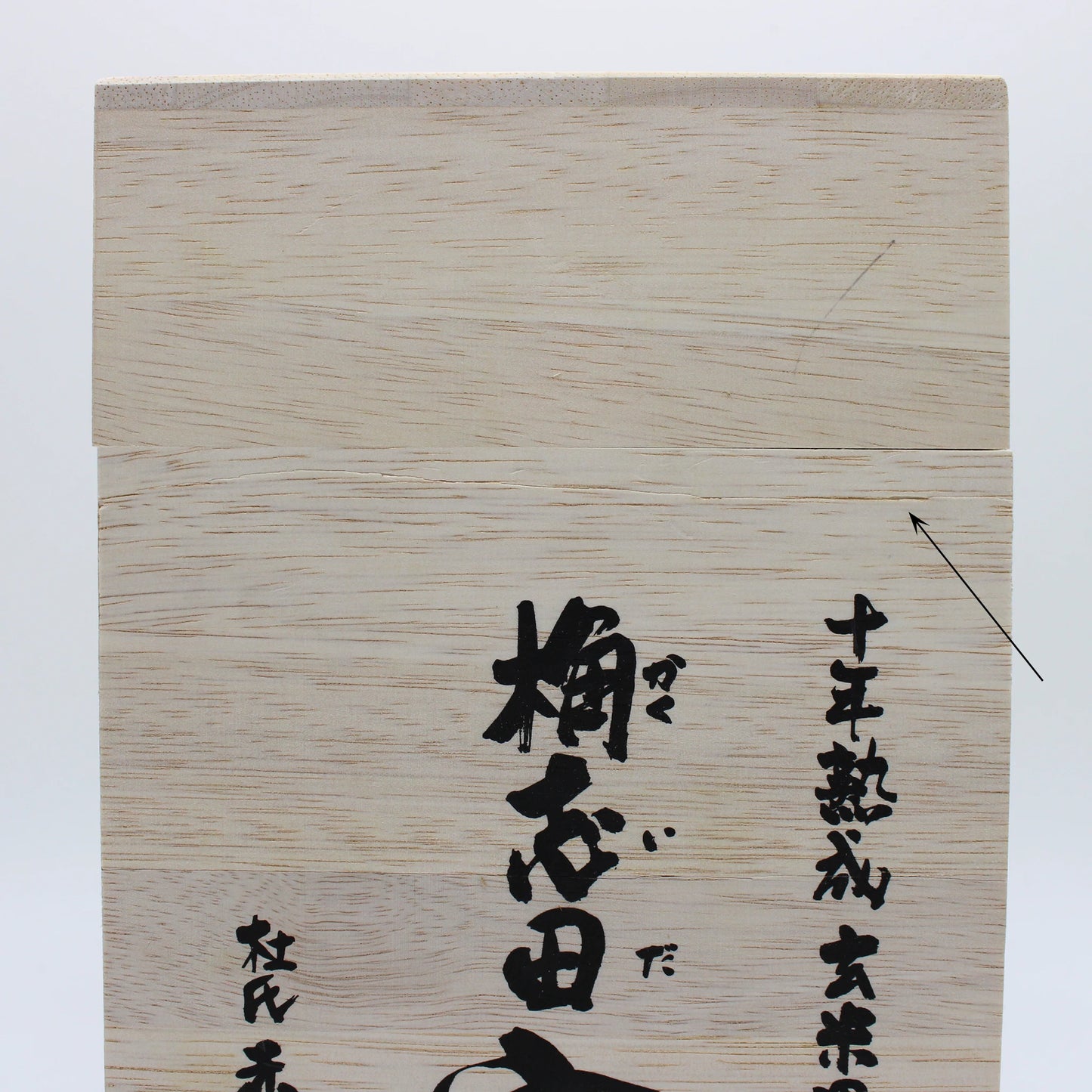 
                  
                    A wooden box with black Japanese calligraphy and a diagonal crack on the upper right once held prized 10 Year Aged Black Rice Vinegar – 1L On Offer, renowned for its exceptional aging and quality.
                  
                