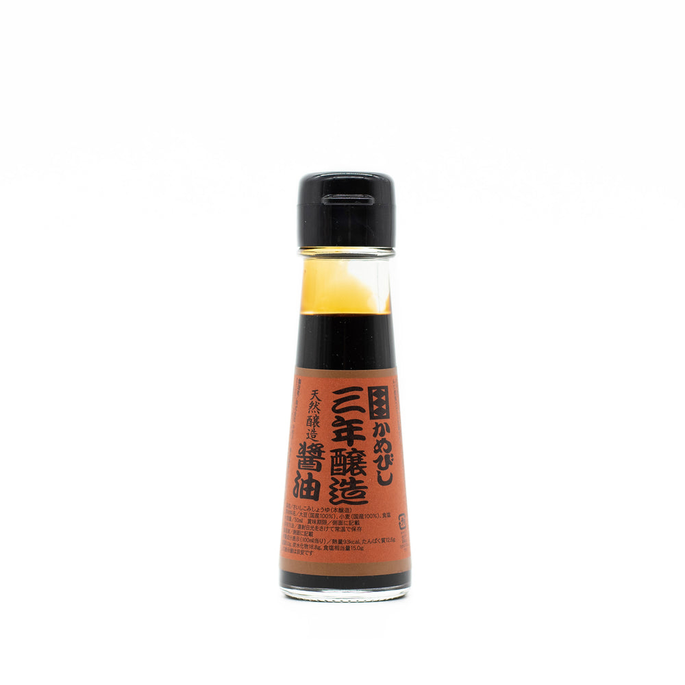 
                  
                    A small glass bottle of 3 Year Aged Soy Sauce with a black cap and an orange label displaying black and red Japanese text, isolated on a white background.
                  
                