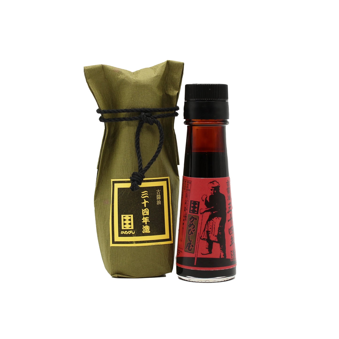 A 55ml glass bottle of 34 Year Aged Soy Sauce stands beside a green paper-wrapped package tied with black string, both labeled with Japanese text.
