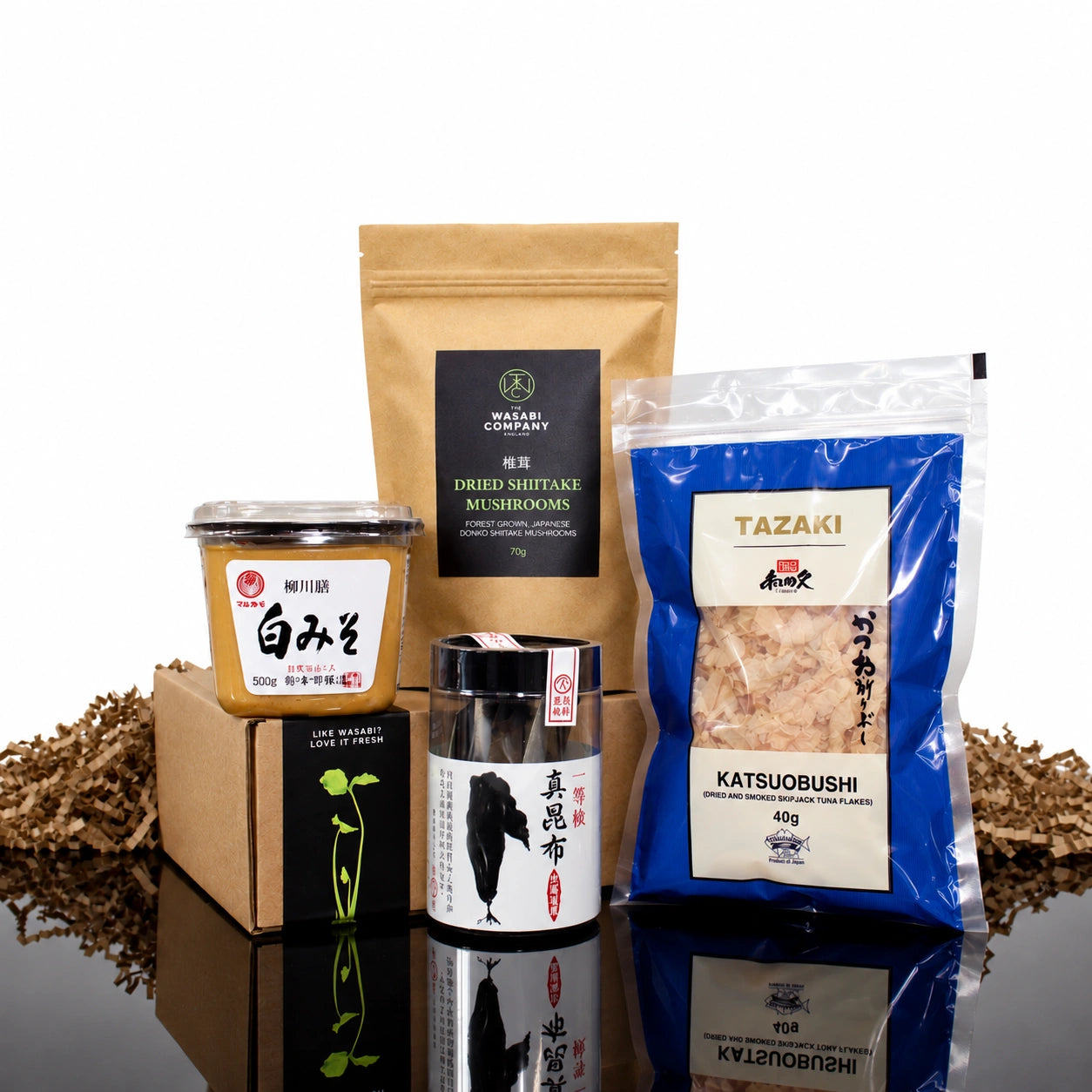 Miso Soup Kit containing a tub of miso paste, a bag of dried shiitake mushrooms, a container of dried kombu, and a bag of katsuobushi flakes.