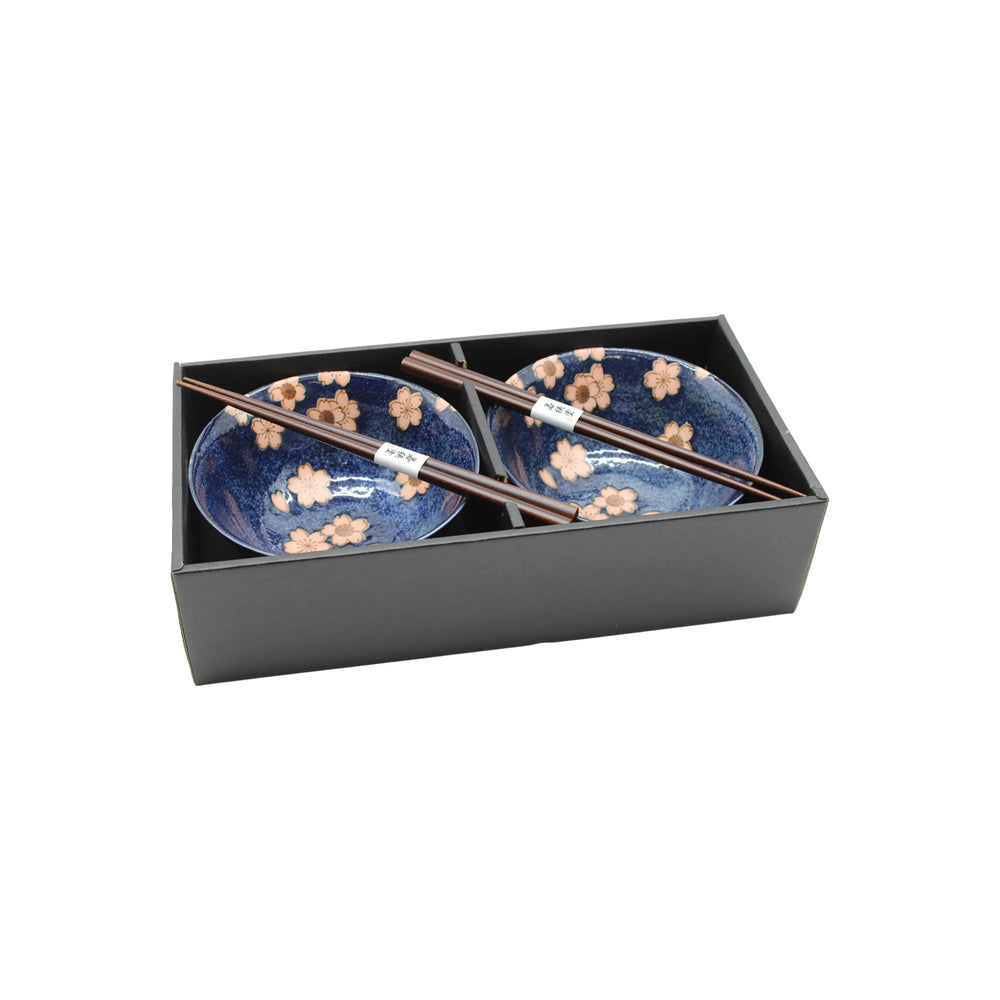 
                  
                    The Cherry Blossom Bowls Boxed Set - Blue with Pink Sakura features two blue bowls with pink sakura designs and two pairs of wooden chopsticks, all presented in a black box.
                  
                