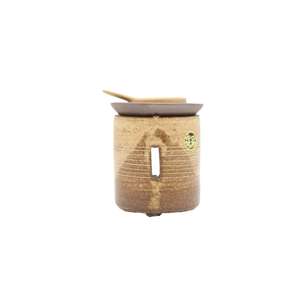 
                  
                    The Chakouro Rustic Brown Japanese Tea Burner is a small, cylindrical ceramic container with a vertical slot, flat lid, and wooden spoon on top, inspired by traditional Japanese design.
                  
                