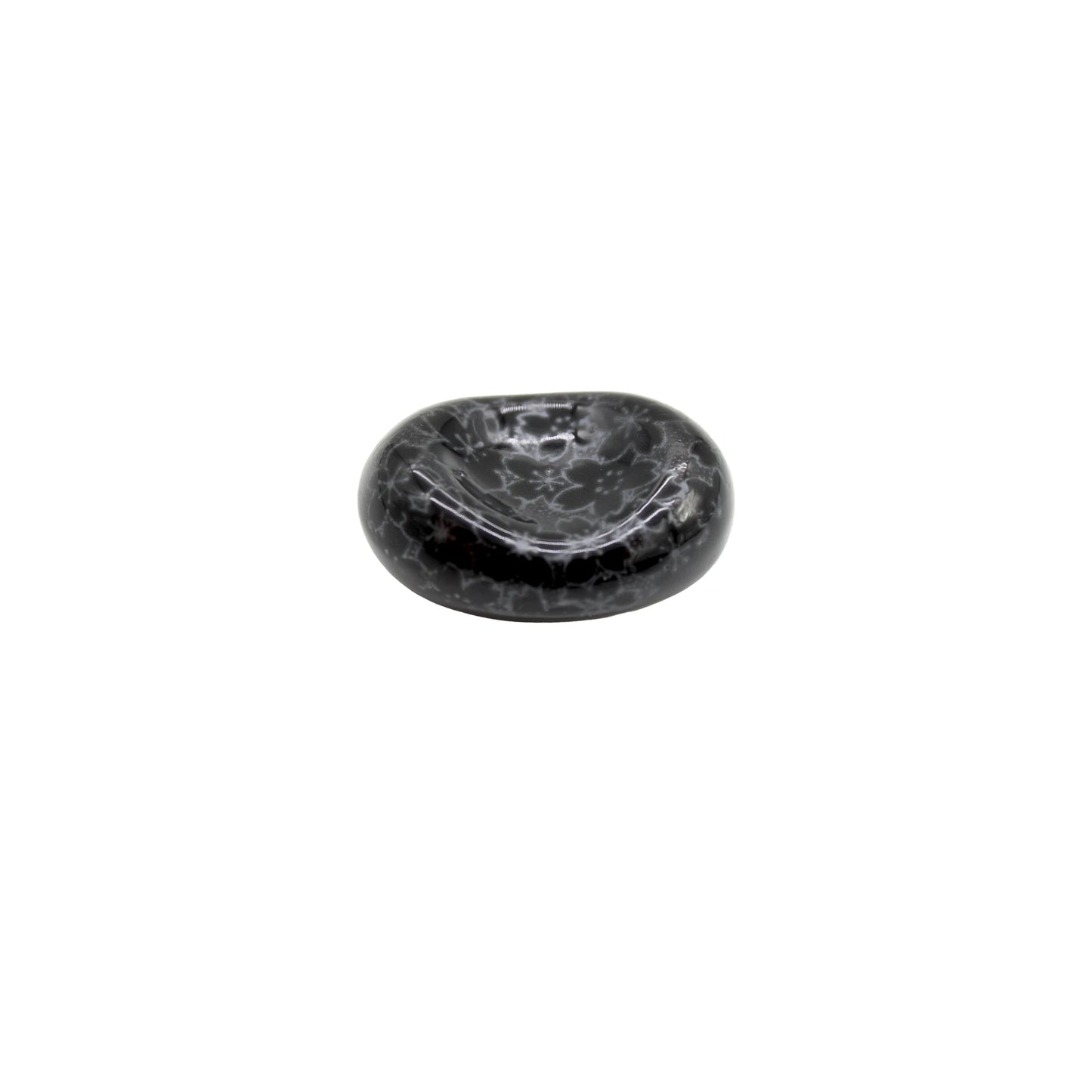 The Chopstick Rest - Pebble Black Sakura is a small, round Minoyaki porcelain piece featuring a smooth, glossy finish and subtle sakura design, shown isolated on a white background.