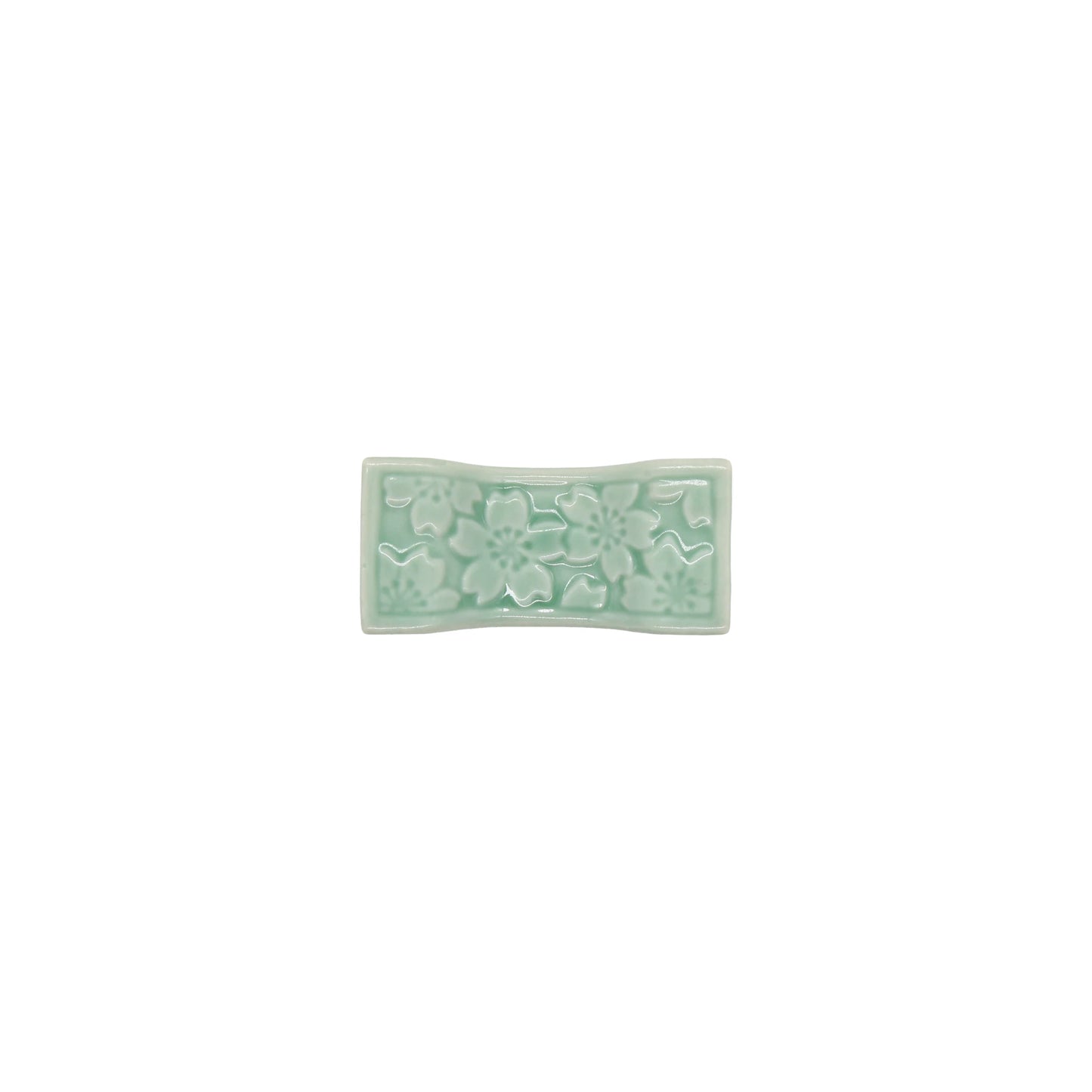 
                  
                    The Chopstick Rest - Sakura Pattern in Celadon Green features a rectangular ceramic shape with an embossed sakura design, set against a white background.
                  
                