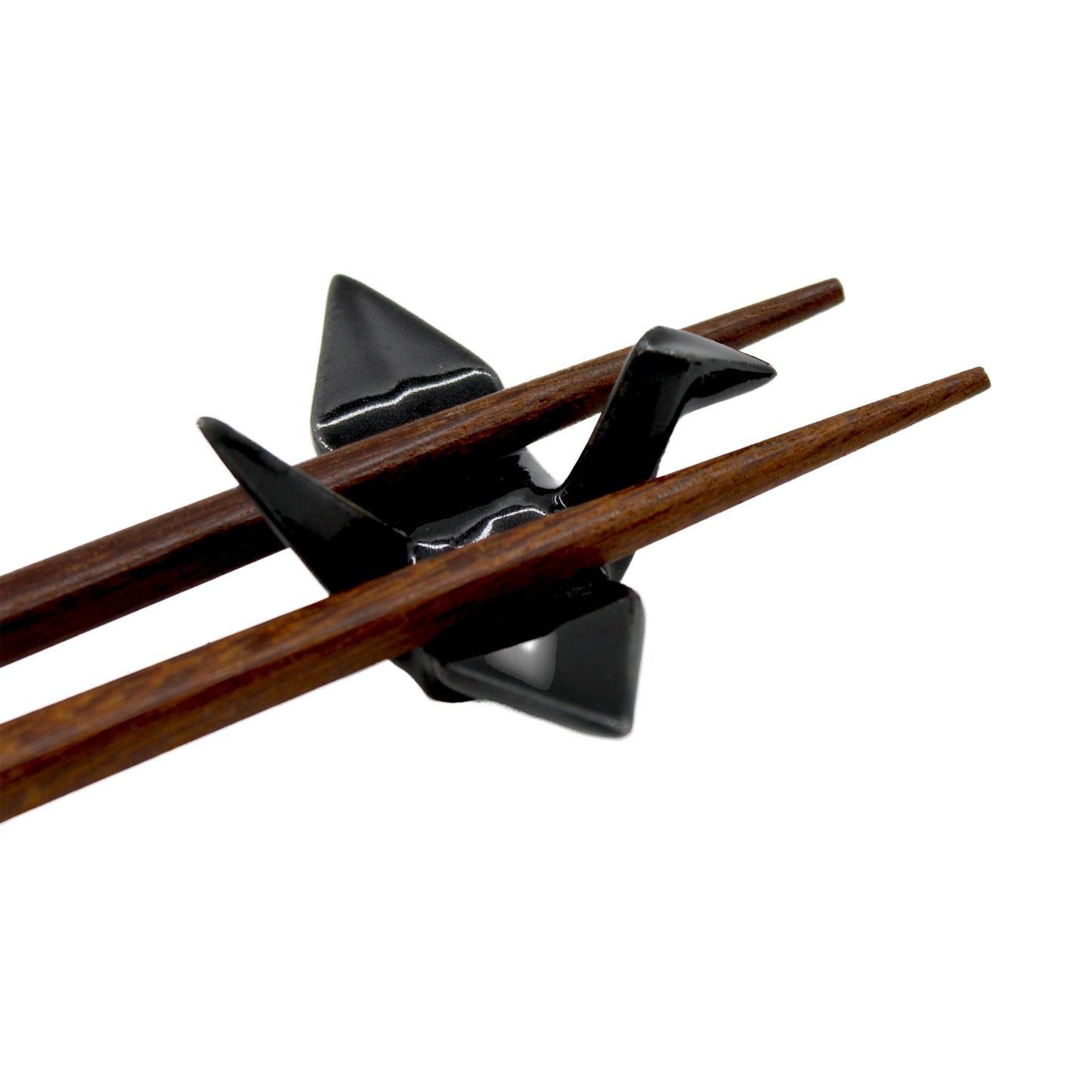 
                  
                    The Chopstick Rest - Origami Crane Black showcases a pair of wooden chopsticks on a sleek black ceramic crane, blending style and Japanese tradition against a white background.
                  
                