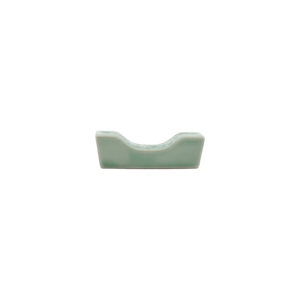 
                  
                    A small, rectangular Chopstick Rest - Sakura Pattern in Celadon Green with a curved center indentation, shown on a plain white background.
                  
                