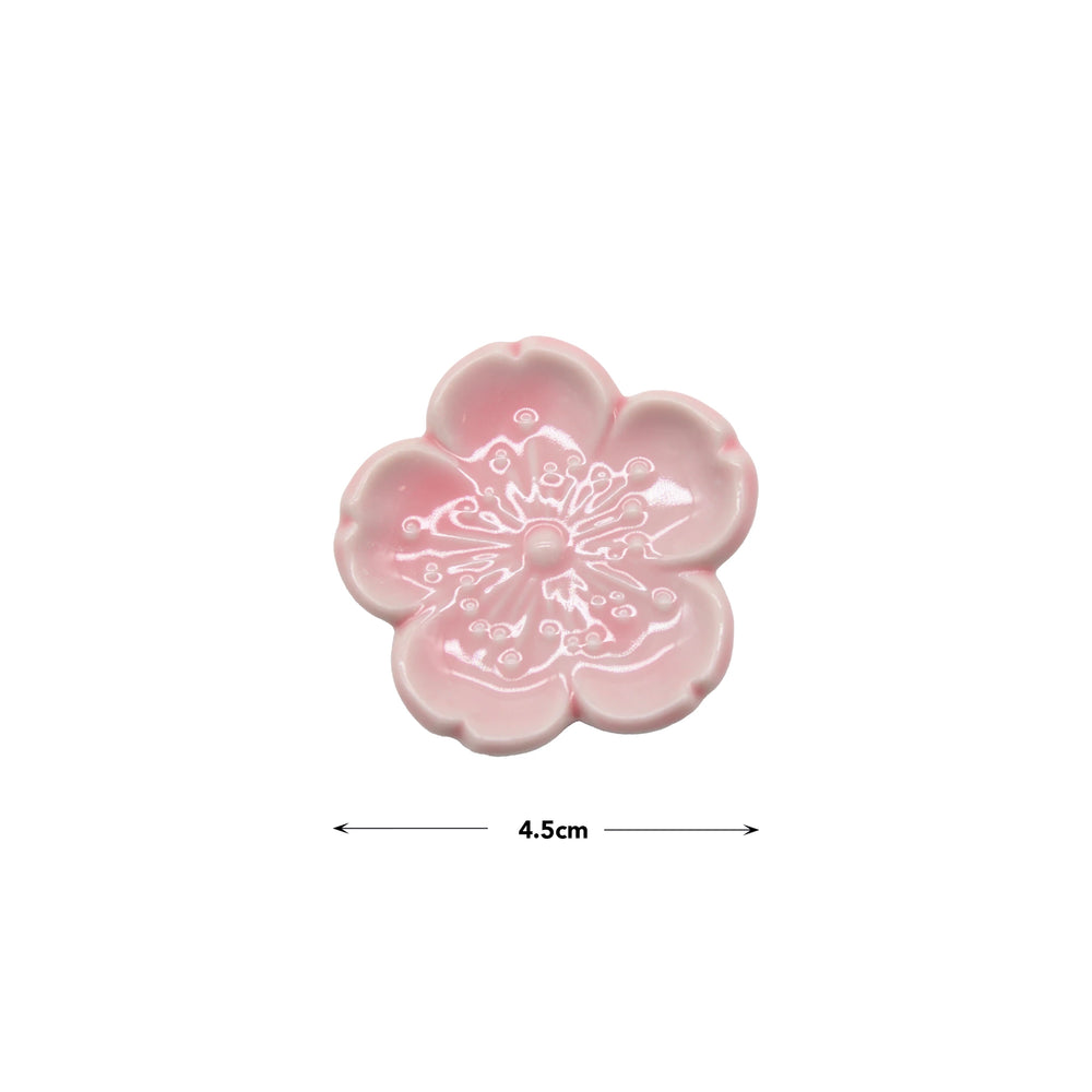 Chopstick Rest - Pink Sakura, made from Minoyaki porcelain, features a delicate white cherry blossom design at the center. Measuring 4.5 cm across, it’s an elegant addition to any Japanese tableware collection.