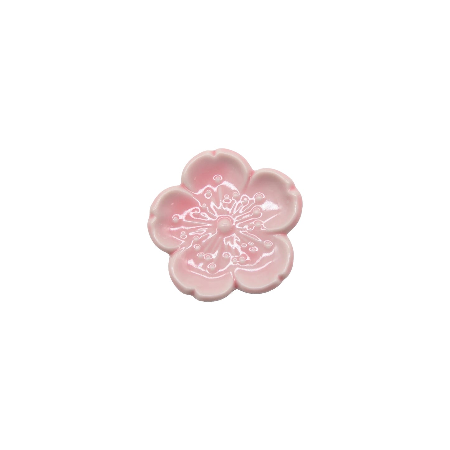 
                  
                    The Chopstick Rest - Pink Sakura is a small, pink Minoyaki porcelain dish shaped like a five-petal flower with embossed details in the center, inspired by Japanese tableware and shown on a white background.
                  
                