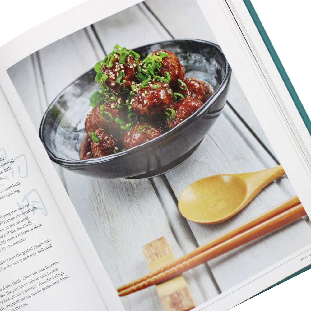 
                  
                    A page from "Cook Japan, Stay Slim, Live Longer by Reiko Hashimoto" features glazed meatballs in a black bowl with green onions and sesame seeds, accompanied by a wooden spoon and chopsticks.
                  
                