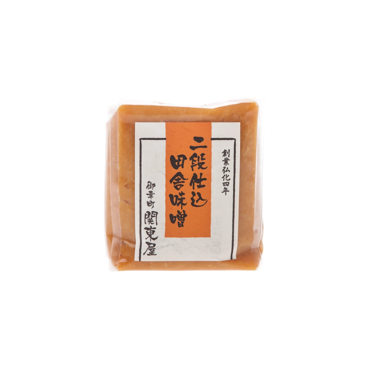 A sealed package of Double Fermented Rustic Miso features an orange and white label with Japanese text and is crafted using a double fermentation process.