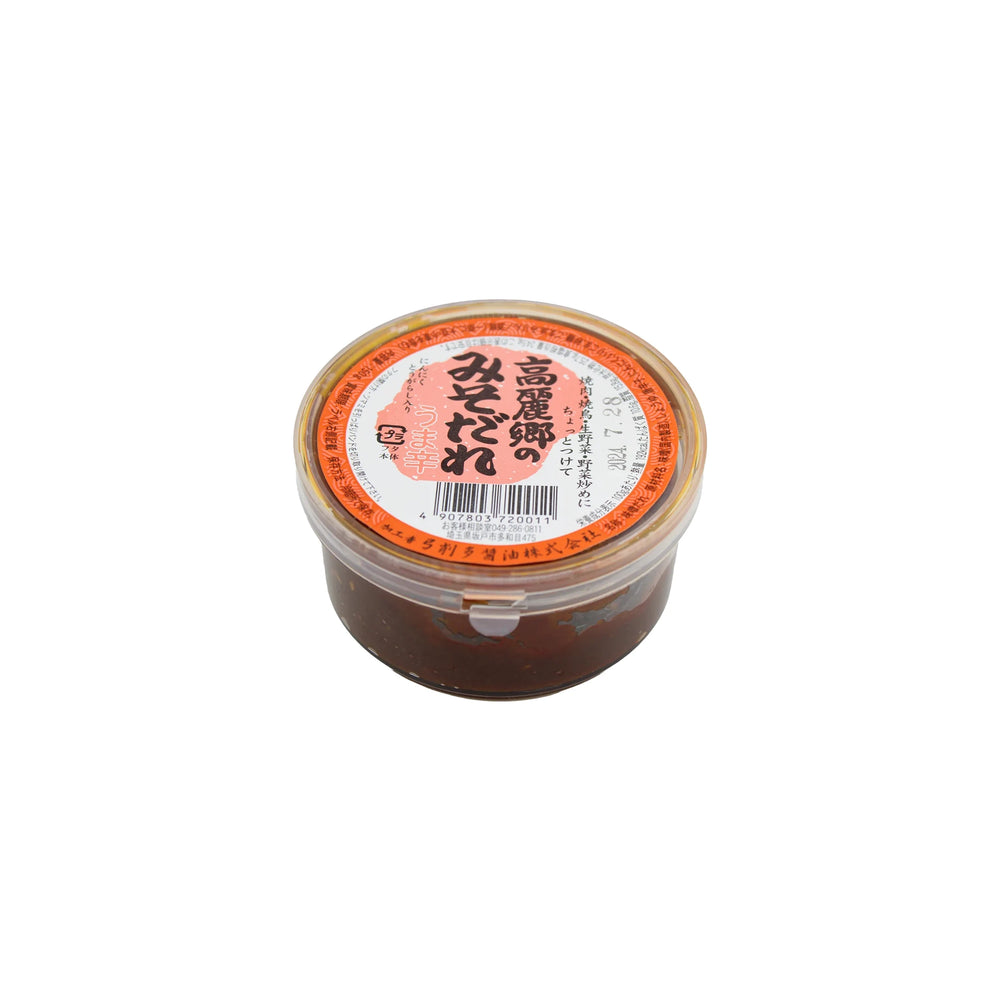 A container of Dare Miso with a red label featuring Japanese text, filled with premium miso paste renowned for its rich umami flavor, displayed against a white background.