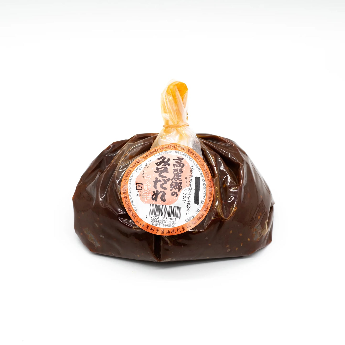 A plastic bag of Dare Miso, dark brown premium miso paste, sealed at the top with a round orange and white label featuring Japanese text—perfect for adding rich umami flavor to soups or as a marinade.