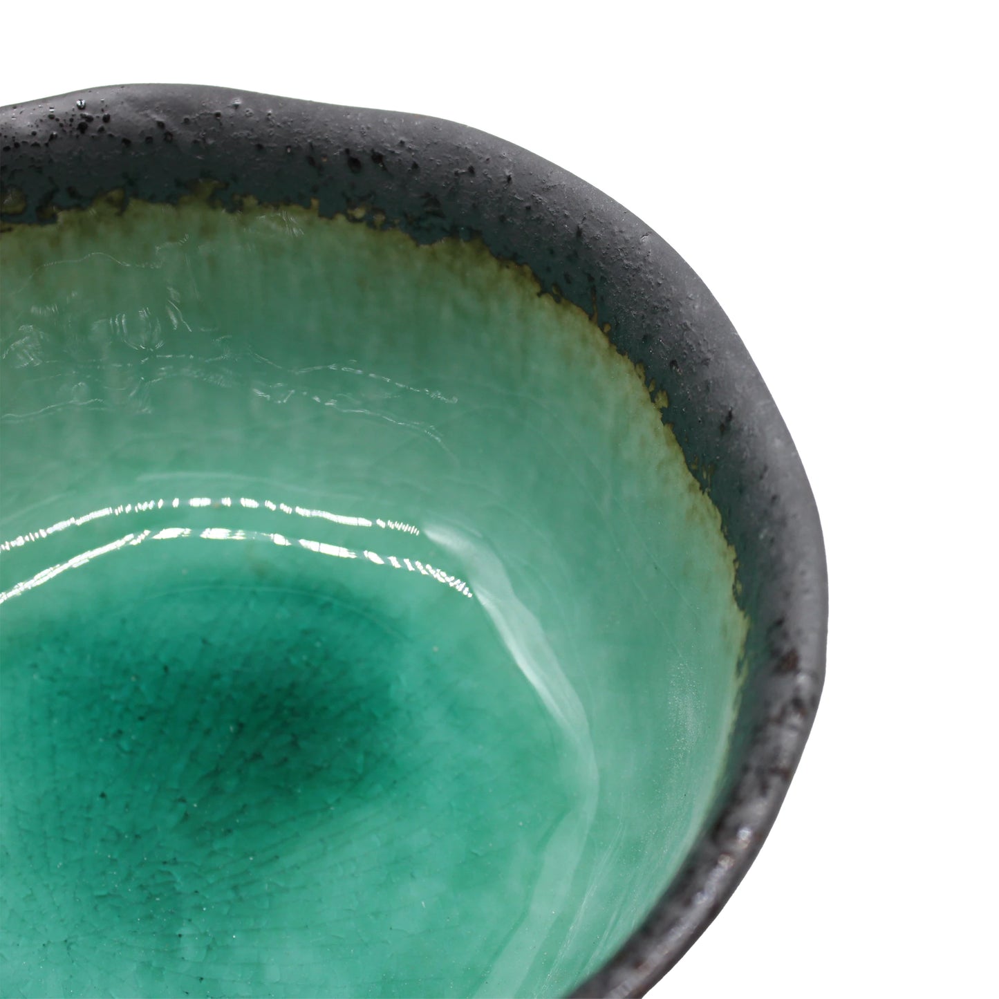 
                  
                    Close-up of the Deep Bowl - Turquoise Crackle Glaze, a Japanese porcelain piece showcasing artisan craftsmanship with a dark rim and glossy green turquoise crackle finish, isolated on white.
                  
                