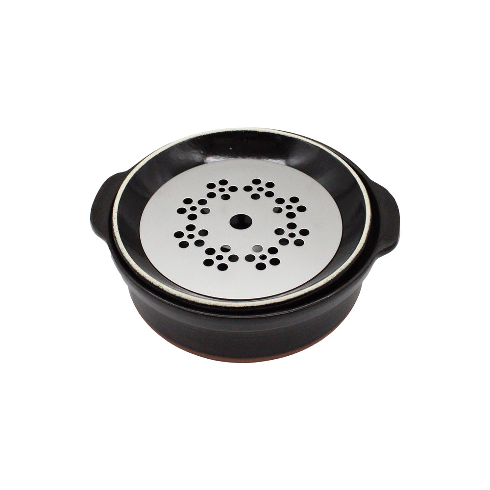 
                  
                    A round black earthenware donabe pot with handles, featuring a white brushstroke design and topped with a removable silver lid with circularly arranged holes.
                  
                