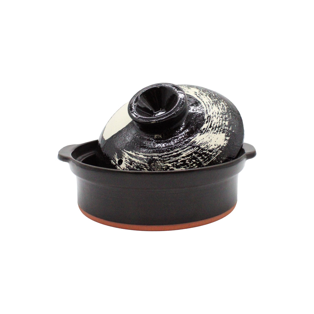 
                  
                    The Black Earthenware Donabe Pot with White Brushstroke Design features a round base, matching domed lid, and is stylish as well as induction compatible.
                  
                