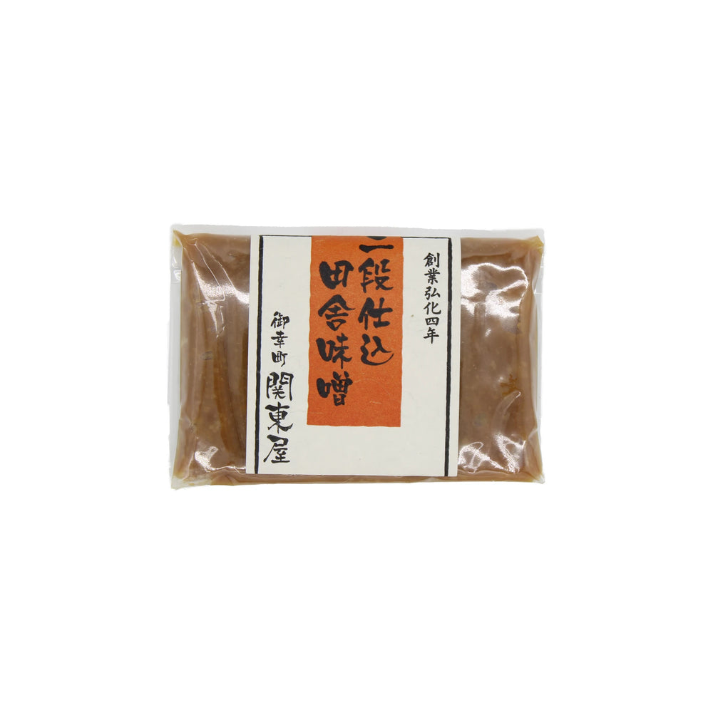 A sealed package of Double Fermented Rustic Miso with a white label featuring black and orange Japanese text, crafted using a traditional twice-fermented process.