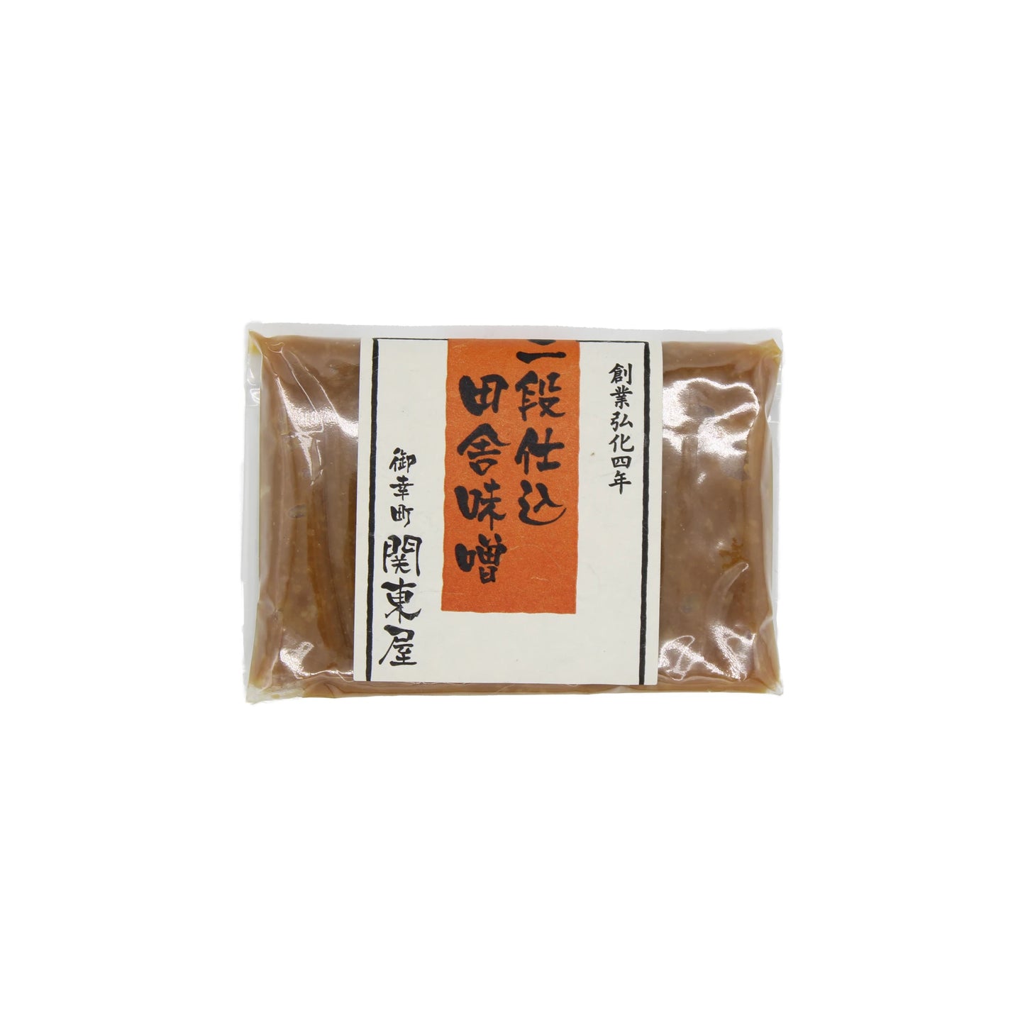 A sealed package of Double Fermented Rustic Miso with a white label featuring black and orange Japanese text, crafted using a traditional twice-fermented process.