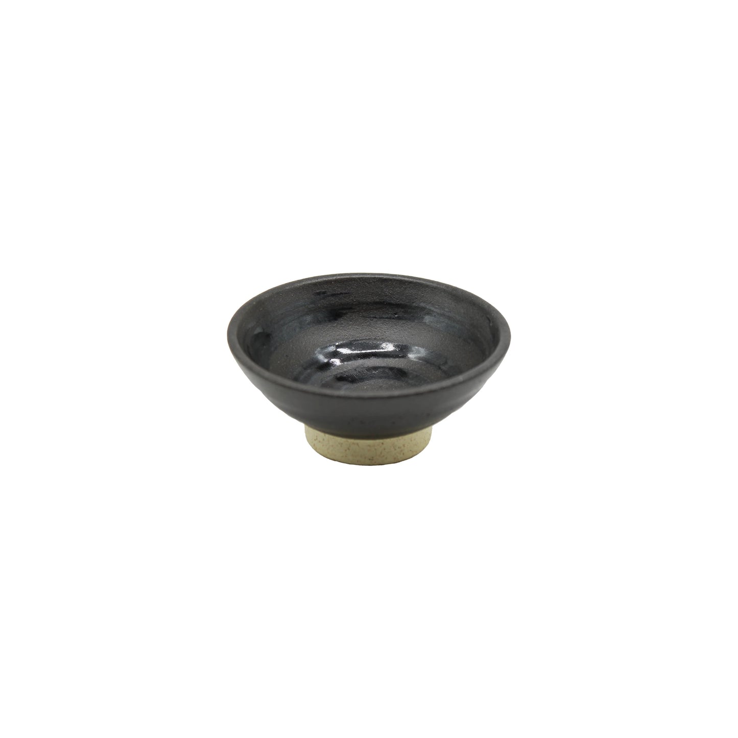 The Sake Cup - Flat Sakazuki in Black Iga Vortex is a small, round cup with a dark, glossy finish and a short, unglazed base, shown on a white background.