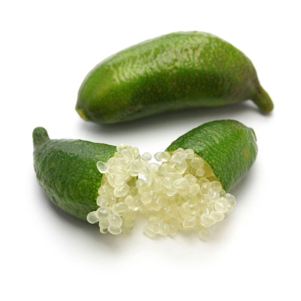 Two Fresh Finger Limes, Citrus Caviar—one whole and one cut open to show translucent citrus pearls—are displayed on a white background.