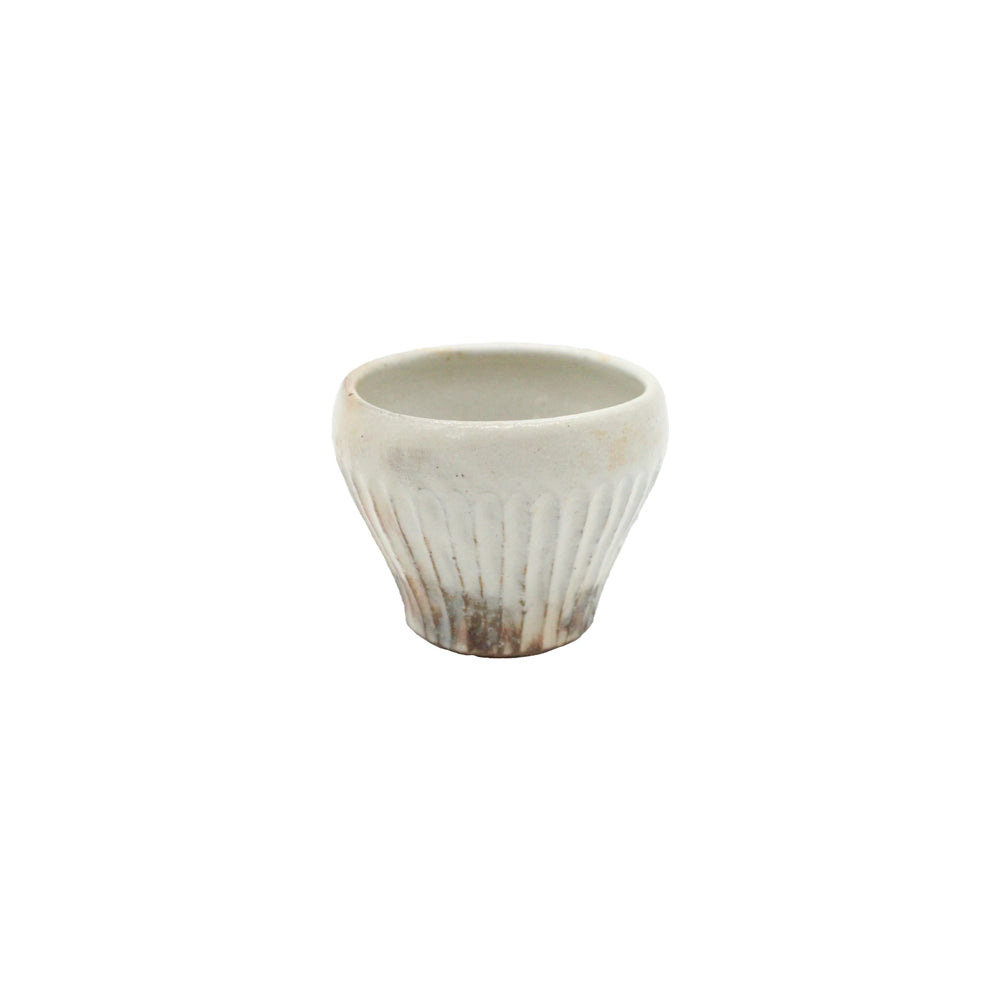 The Tea Mug - Iron Scatter is a small, round, white ceramic cup with subtle vertical ridges, a slightly flared rim, and a classic Kohiki finish inspired by Japanese pottery, displayed on a plain white background.