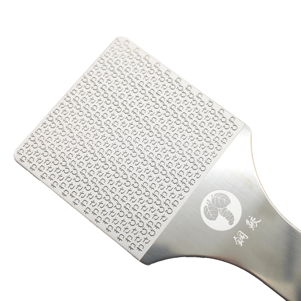 A close-up of the Hagane-zame Wasabi Graters, featuring fine, sharp stainless-steel etched blades and a lobster logo engraved on the handle.