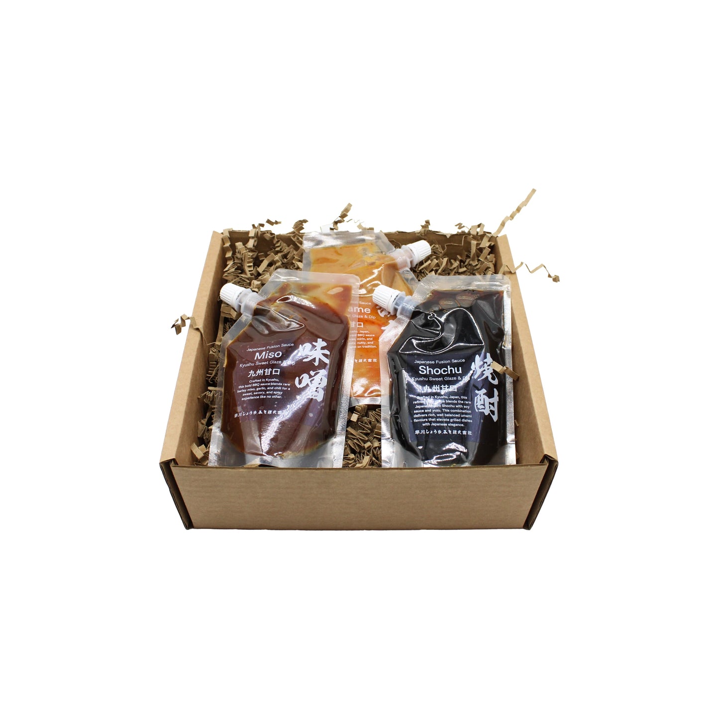 The Hayakawa BBQ Sauce Set comes in a cardboard box with three clear pouches of Japanese sauces, nestled in brown shredded packing paper—perfect for exploring unique flavors.