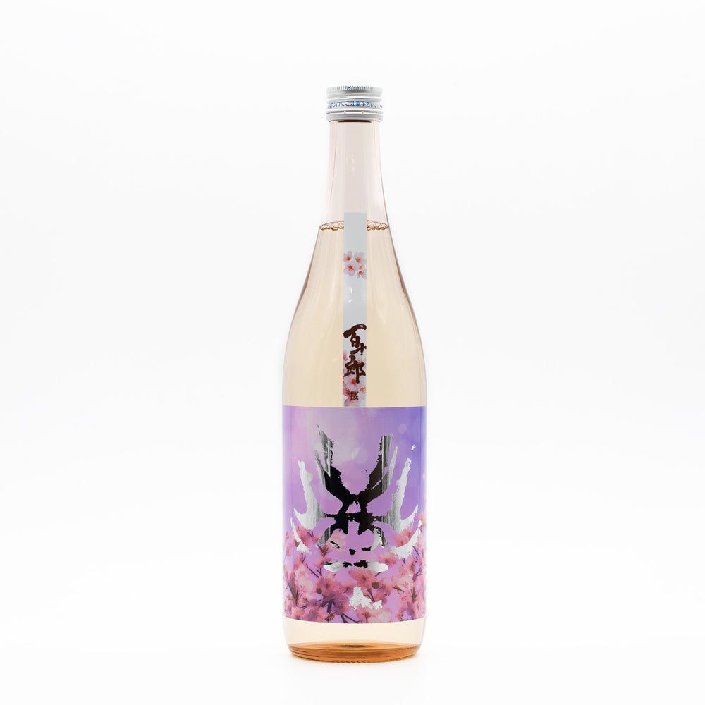 The Hyakujuro Sakura Junmai Daiginjo (720ml) comes in a clear glass bottle with light pink liquid and a purple and pink label featuring an abstract, symmetrical Sakura cherry blossom-inspired design.